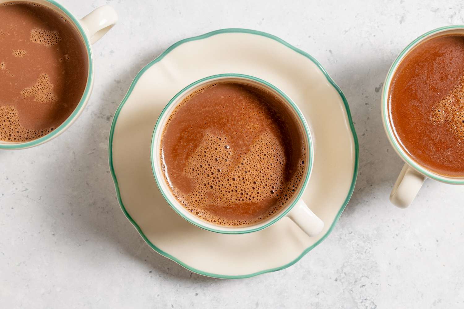 Three cups of French hot chocolate on a white surface