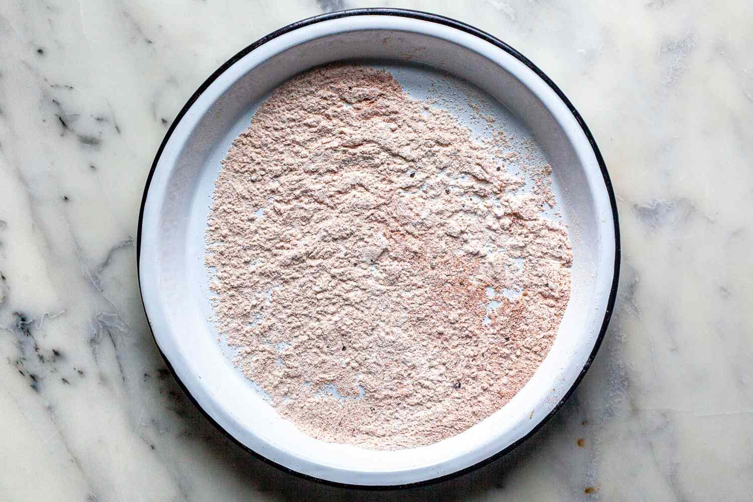 Seasoned flour in a dish to make a Southern smothered chicken recipe.