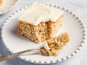 square slice of Feather Cake on a plate with a fork with a small bite portion on it