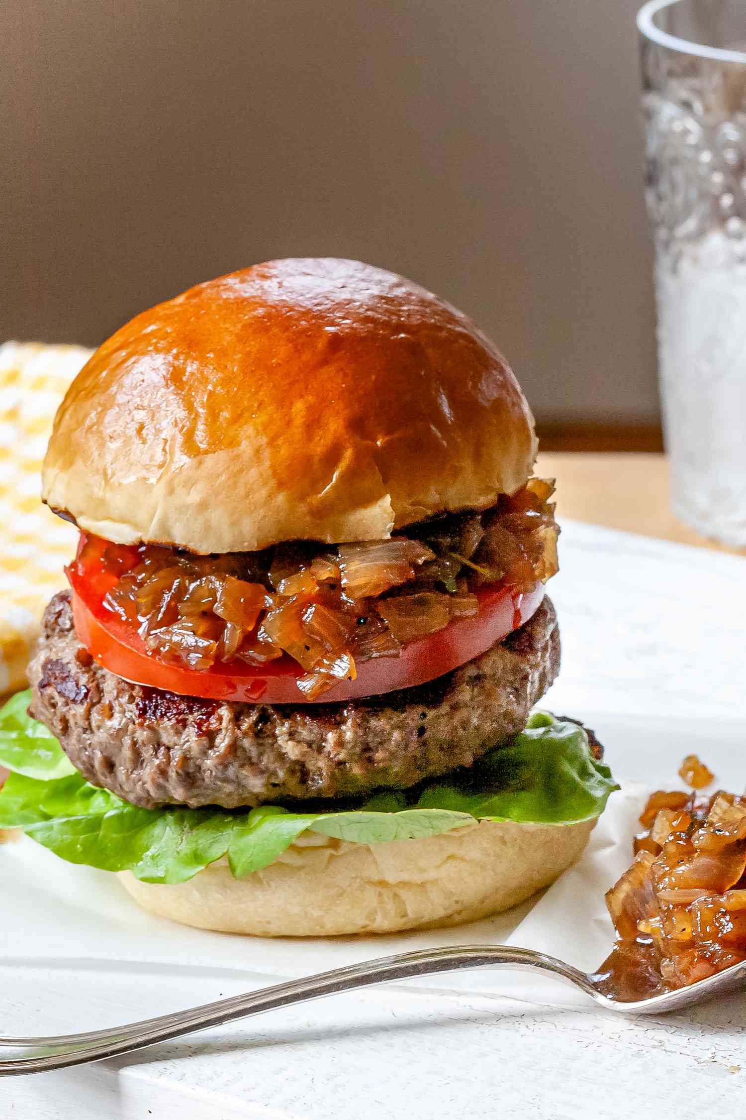 Burger condiment: burger jam spread on a burger and with a spoonful in front of the hamburger.