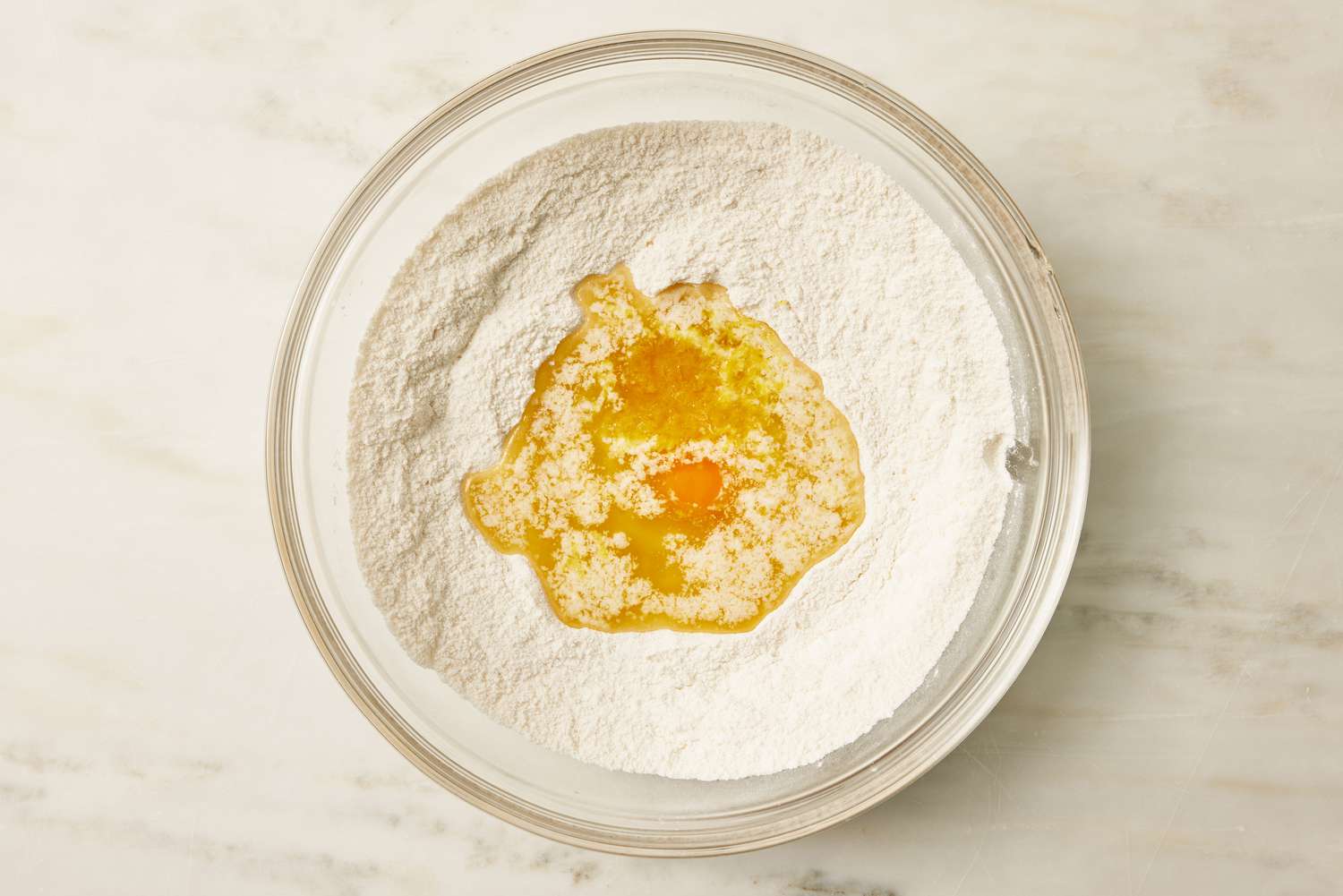 overhead view of large bowl of flour with egg mixture added in for Lemon Gooey Butter Cake recipe
