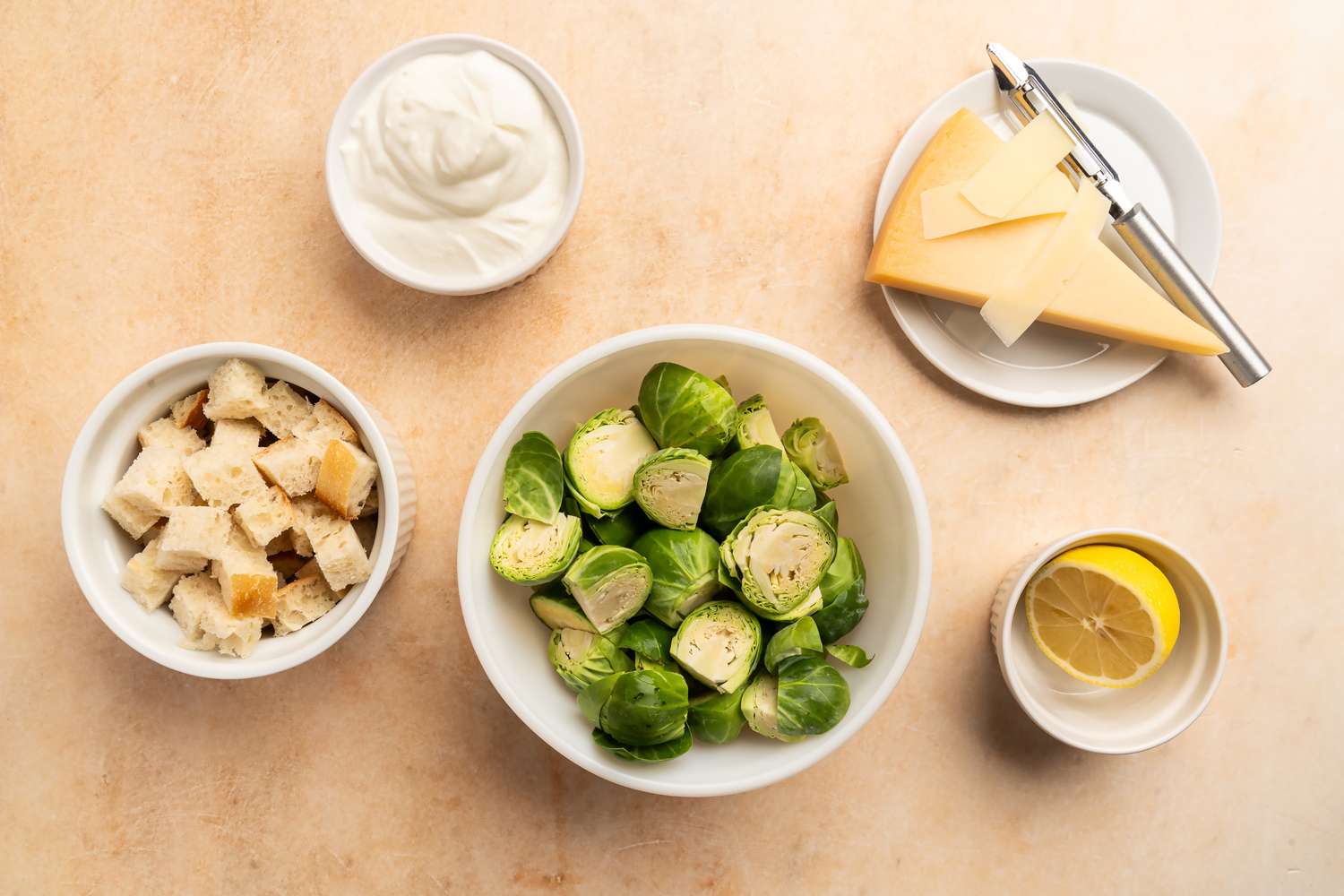 Arranged ingredients include Brussels sprouts croutons cream cheese and a lemon slice
