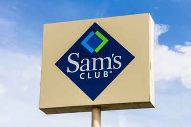 Sign with the Sams Club logo on a post against a partly cloudy sky