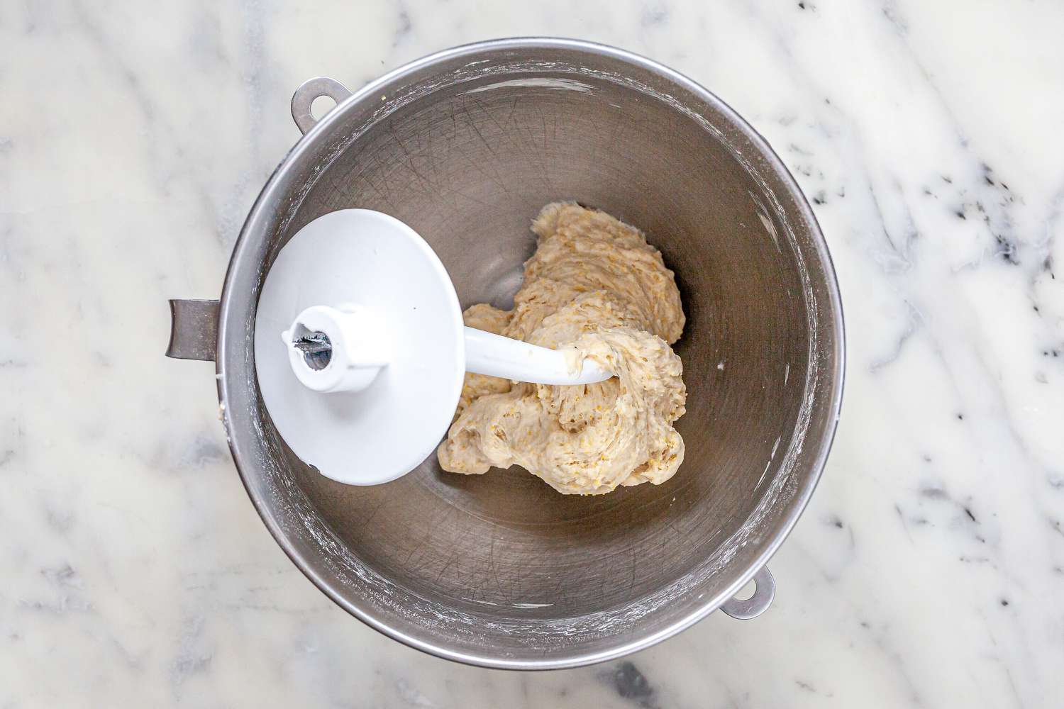 Kneading attachment in the bowl of a stand mixer to make Chicago-Style Deep Dish Pizza.