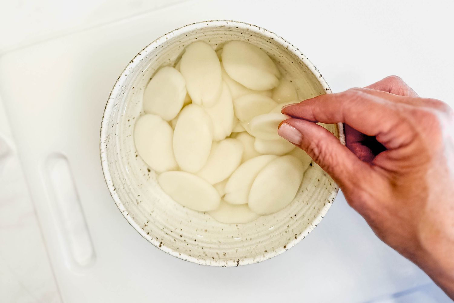 Disk rice cakes soaking in a bowl of water for budae jjigae (army base stew) recipe