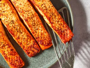 Cooked salmon fillets on a plate with a spatula