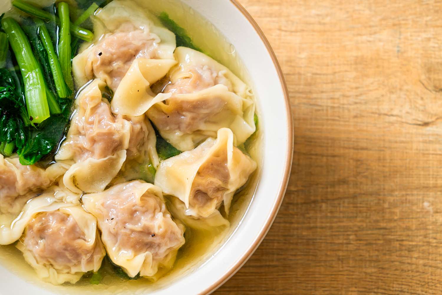 Dumpling in a bowl of soup with greens