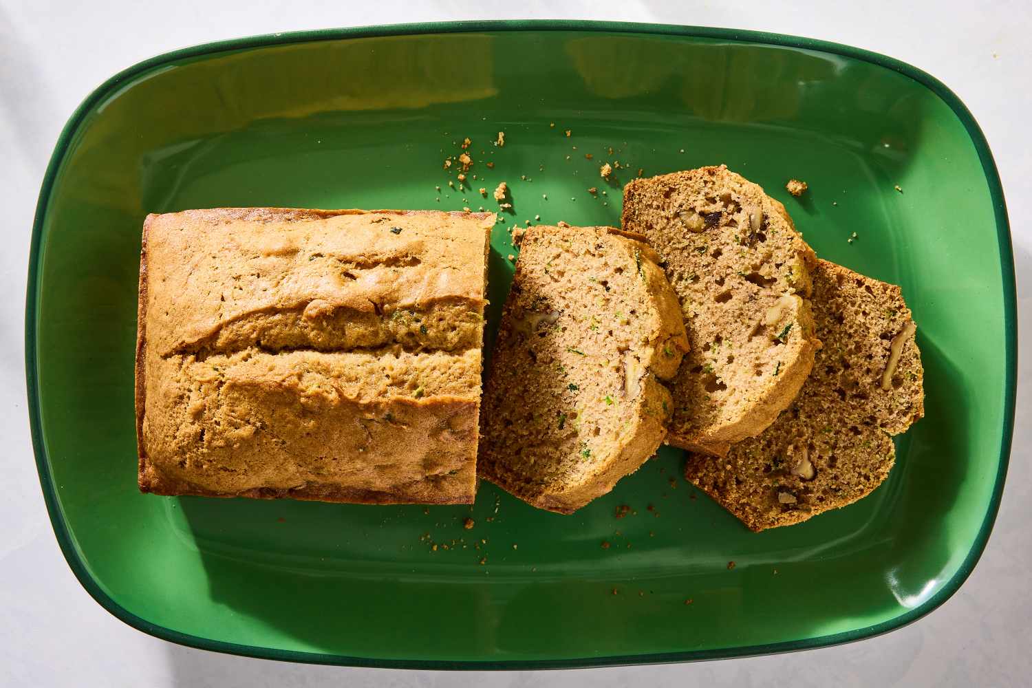 Sliced loaf of zucchini bread on a green plate