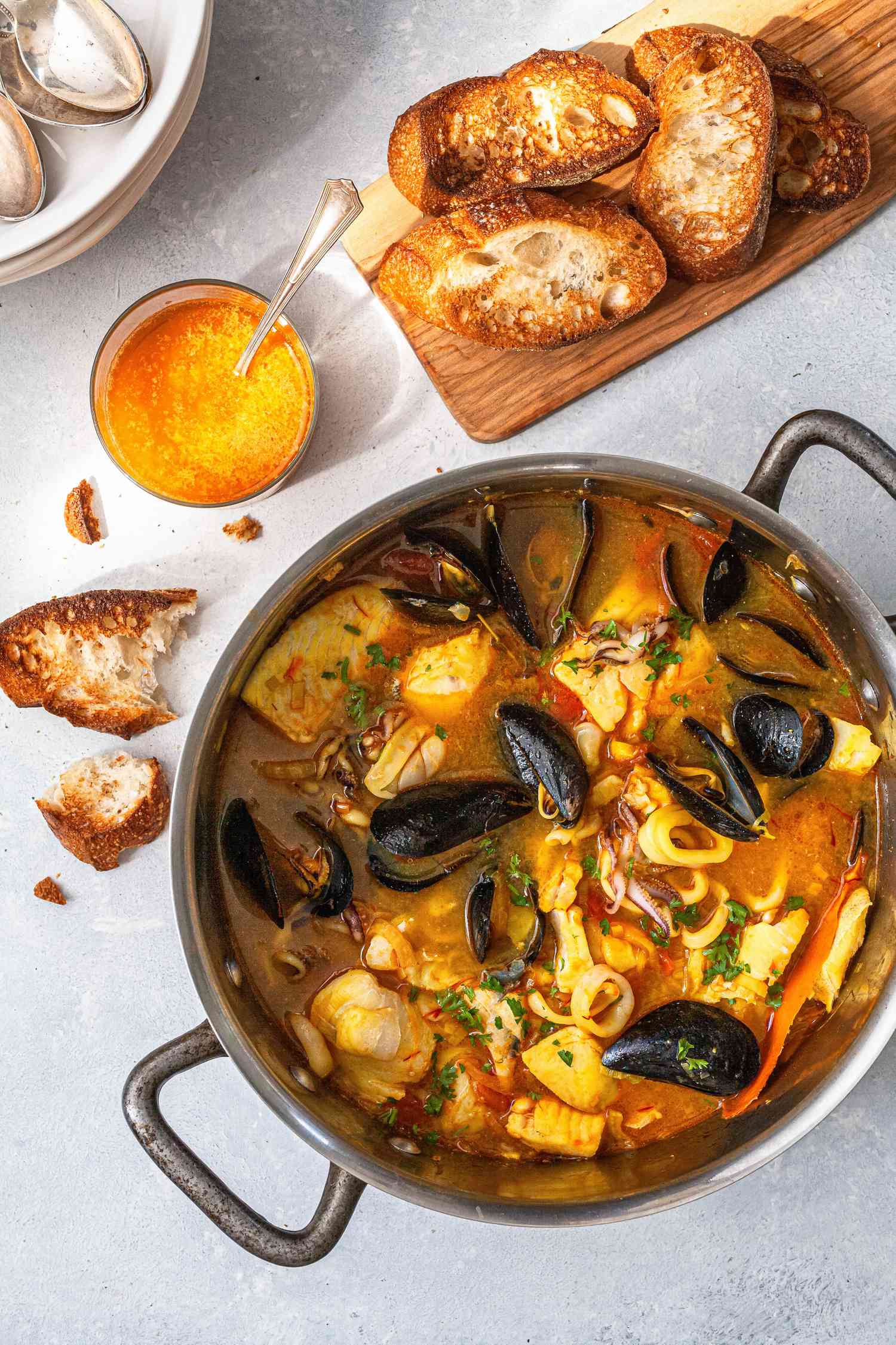 Overhead view of a pot of bouillabaisse and bread.