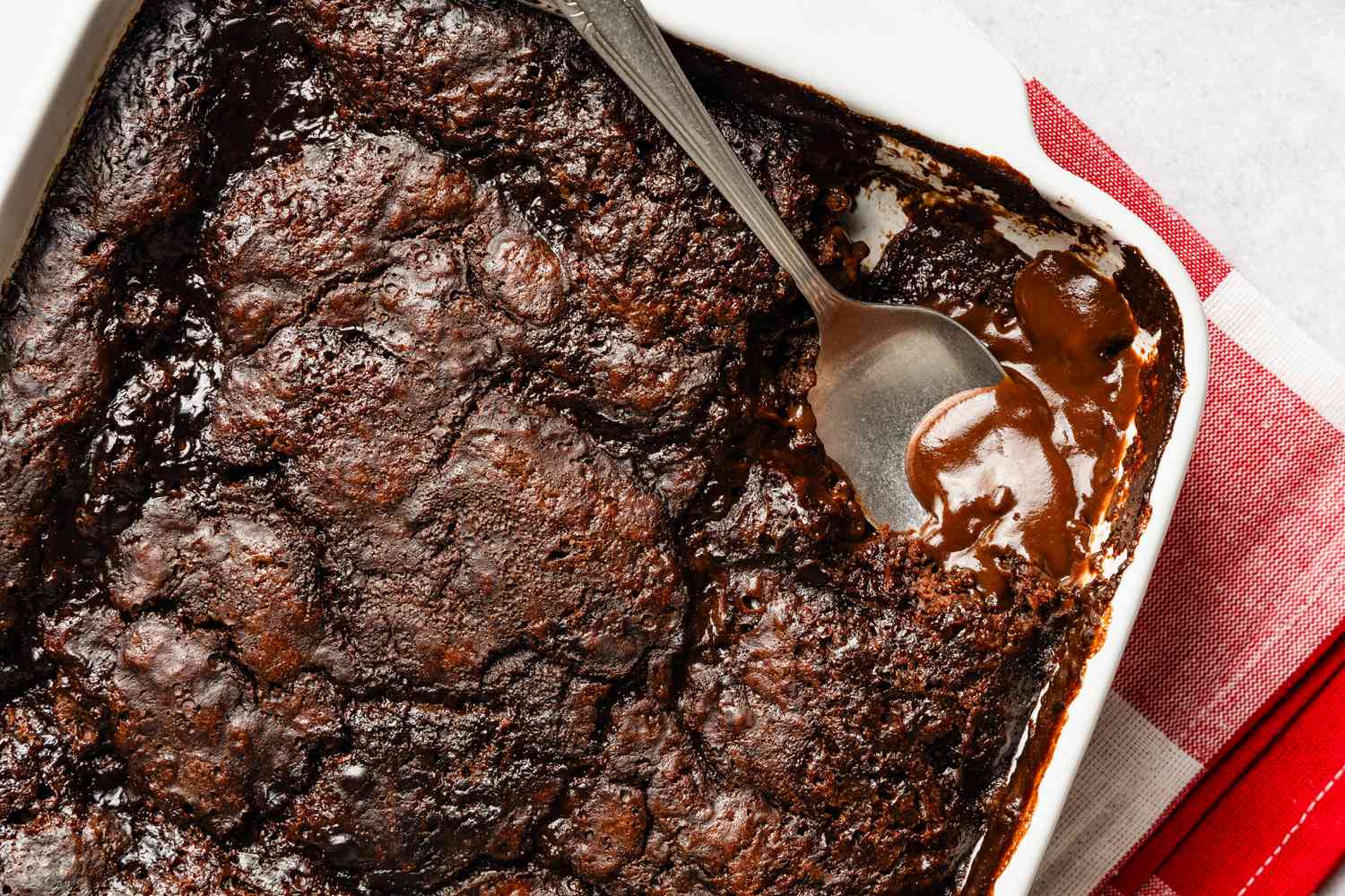 Chocolate pudding cake in a baking pan with a slice cut out