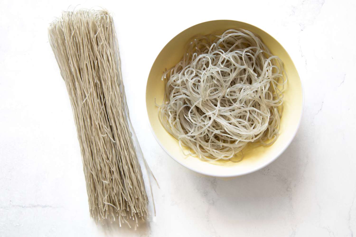 Dried Japchae Noodles on the Left and Cooked Japchae Noodles in a Bowl on the Right
