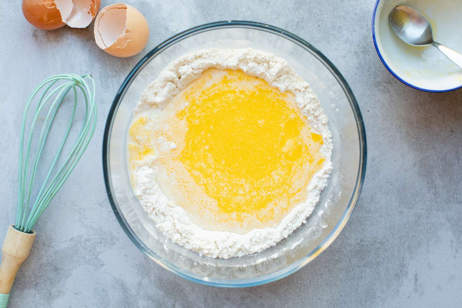 Dry and wet ingredients in a glass bowl to make toad in the hole recipe.
