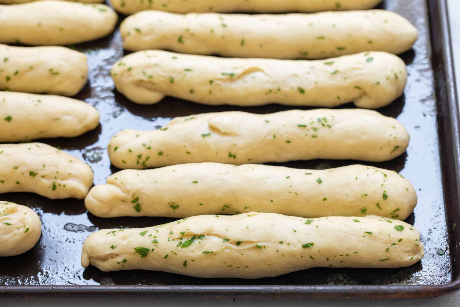 Breadsticks with Garlic Butter on a Baking Pan 