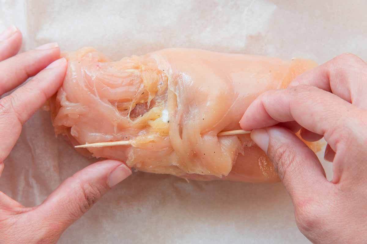 Chicken breast rolled and being secured with a toothpick