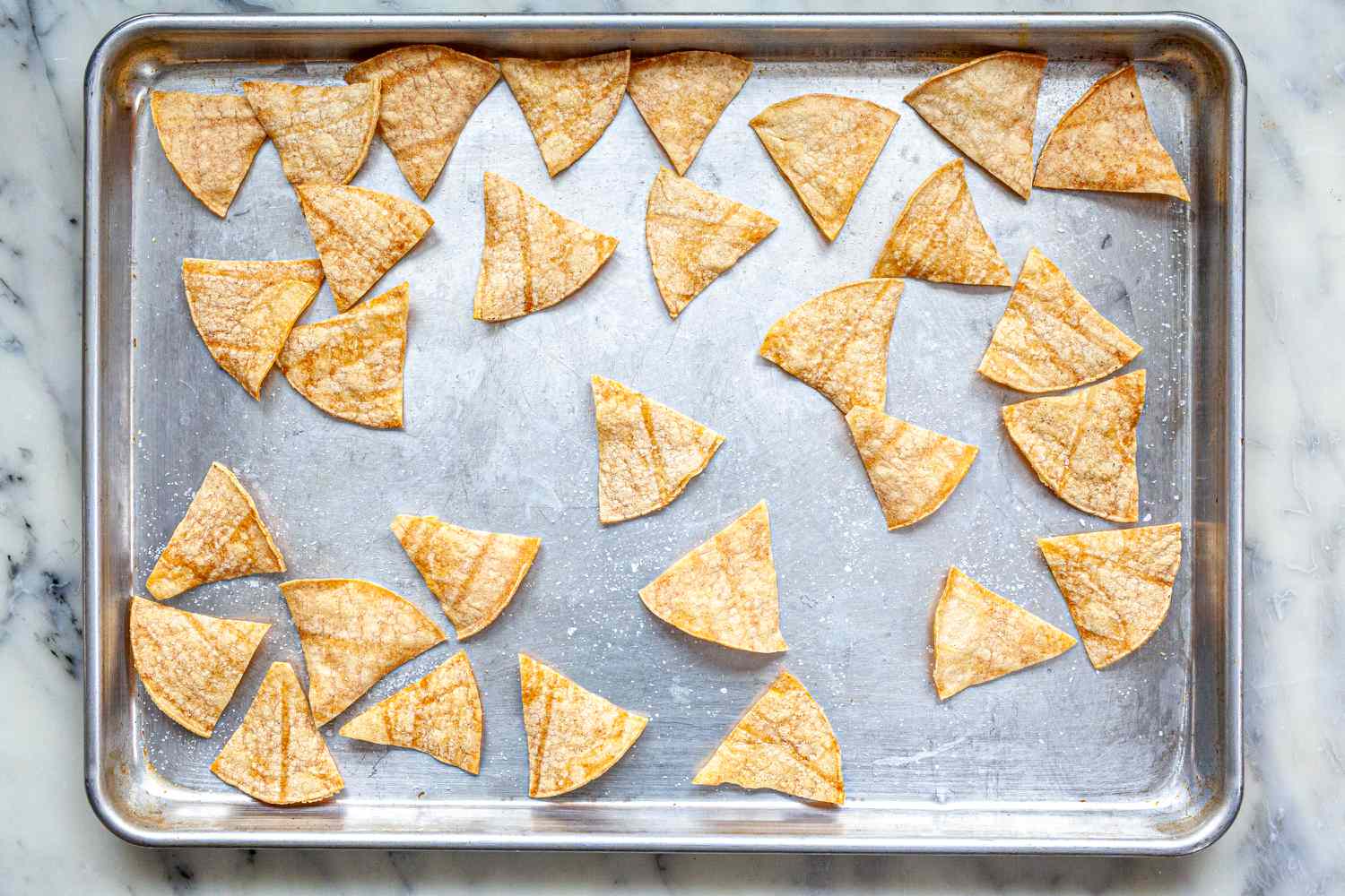 A sheet pan with crispy tortilla chips on it.