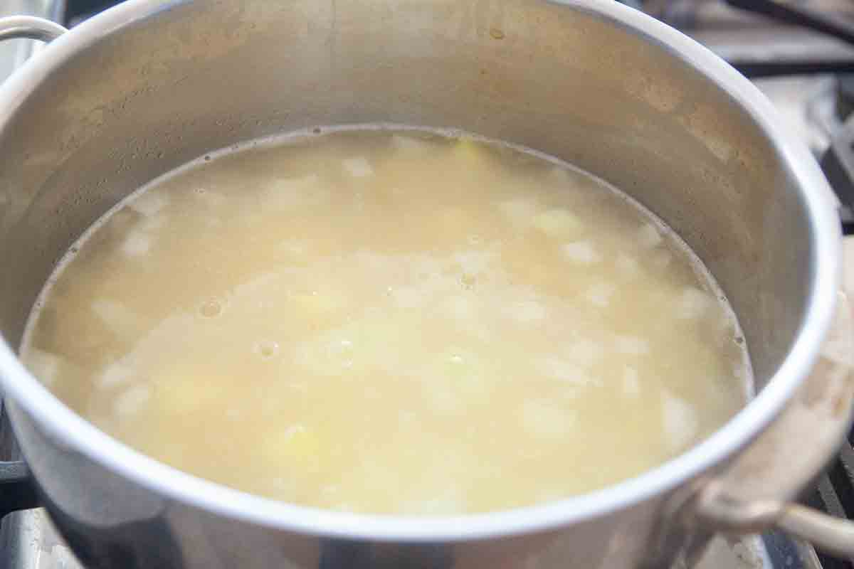 potatoes cooking in stock in pot for watercress soup