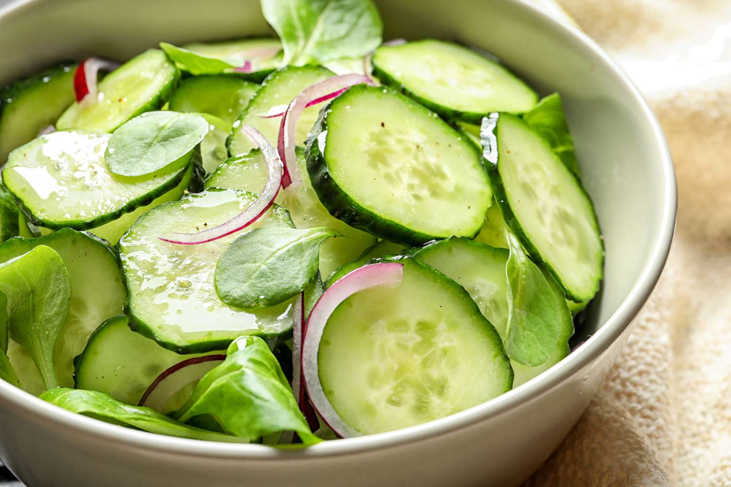 Cucumber salad in a bowl with onions and greens