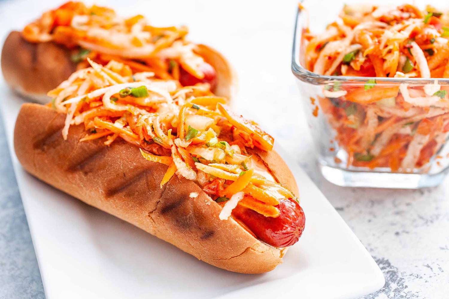 Two kimchi slaw hot dogs ready to eat