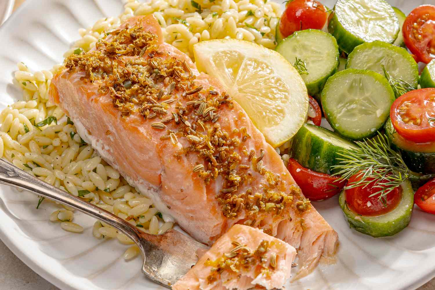 4-ingredient mediterranean salmon on a plate with rice and fresh vegetables