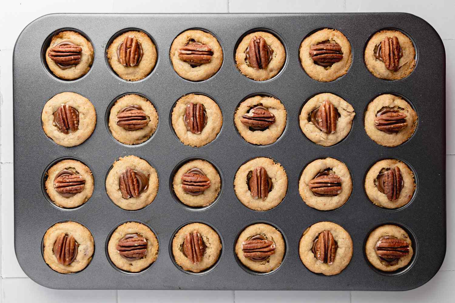 Rolos and Pecan Halves Added to Turtle Cookie Cups in Mini Muffin Tray