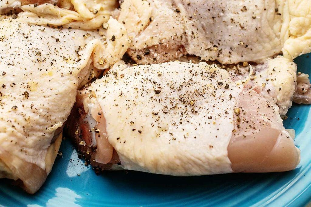 Season chicken thighs for cider-braised chicken thighs recipe