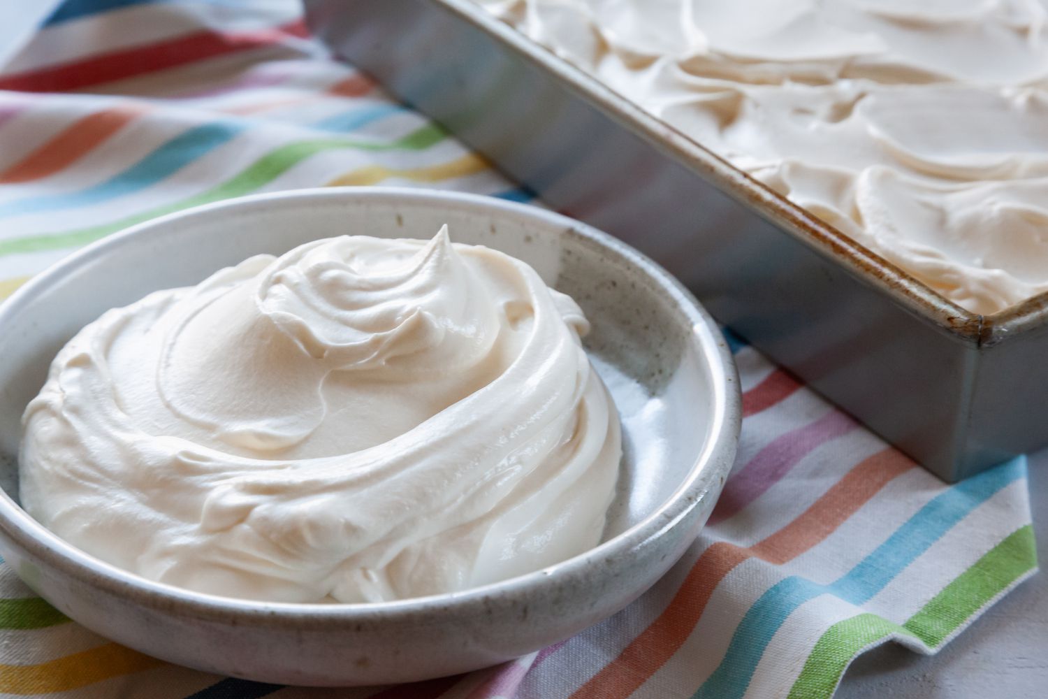 Close up view of a small bowl of whipped cream frosting.