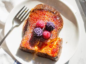 creme brulee french toast topped with berries and powdered sugar
