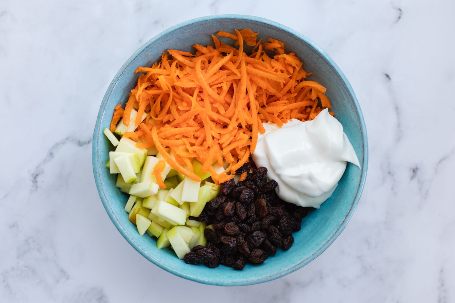 Ingredients to make a Classic Carrot Salad in a bowl.