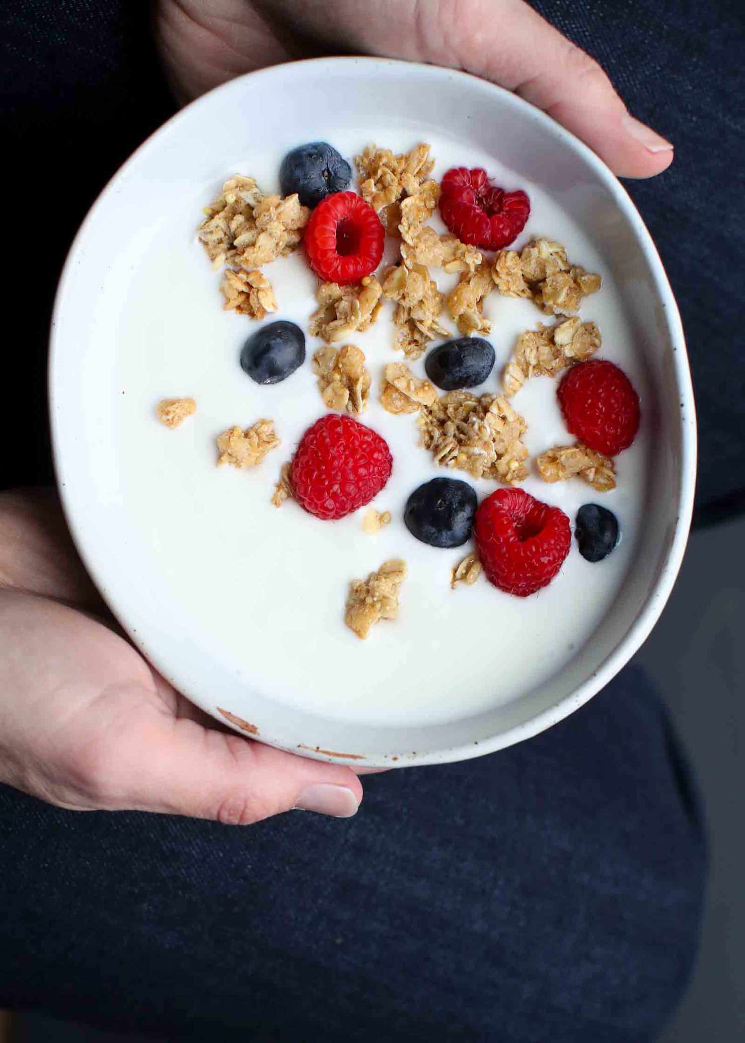 A bowl of Yogurt with granola and berries in it 