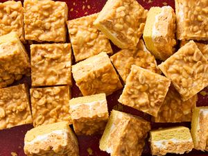 Salted nut roll bars cut into squares arranged on a surface