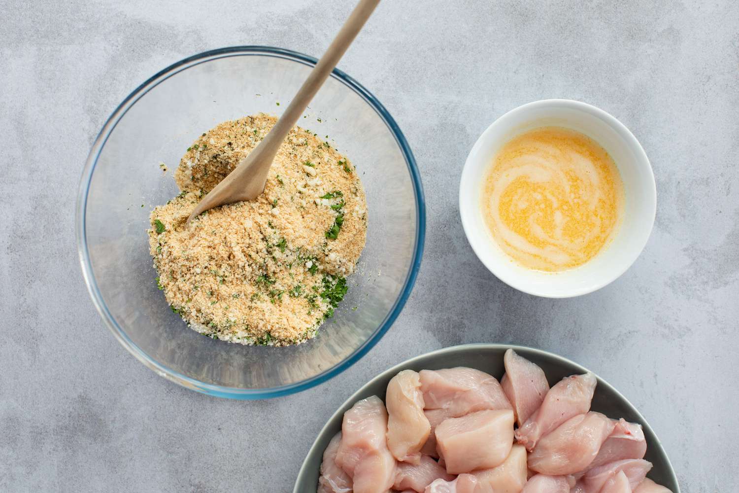 Overhead view of bread crumbs and wet ingredients to make breaded chicken breast recipes.