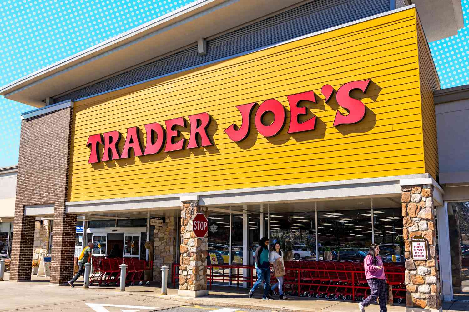 Exterior view of a Trader Joe's store entrance with patrons entering and exiting