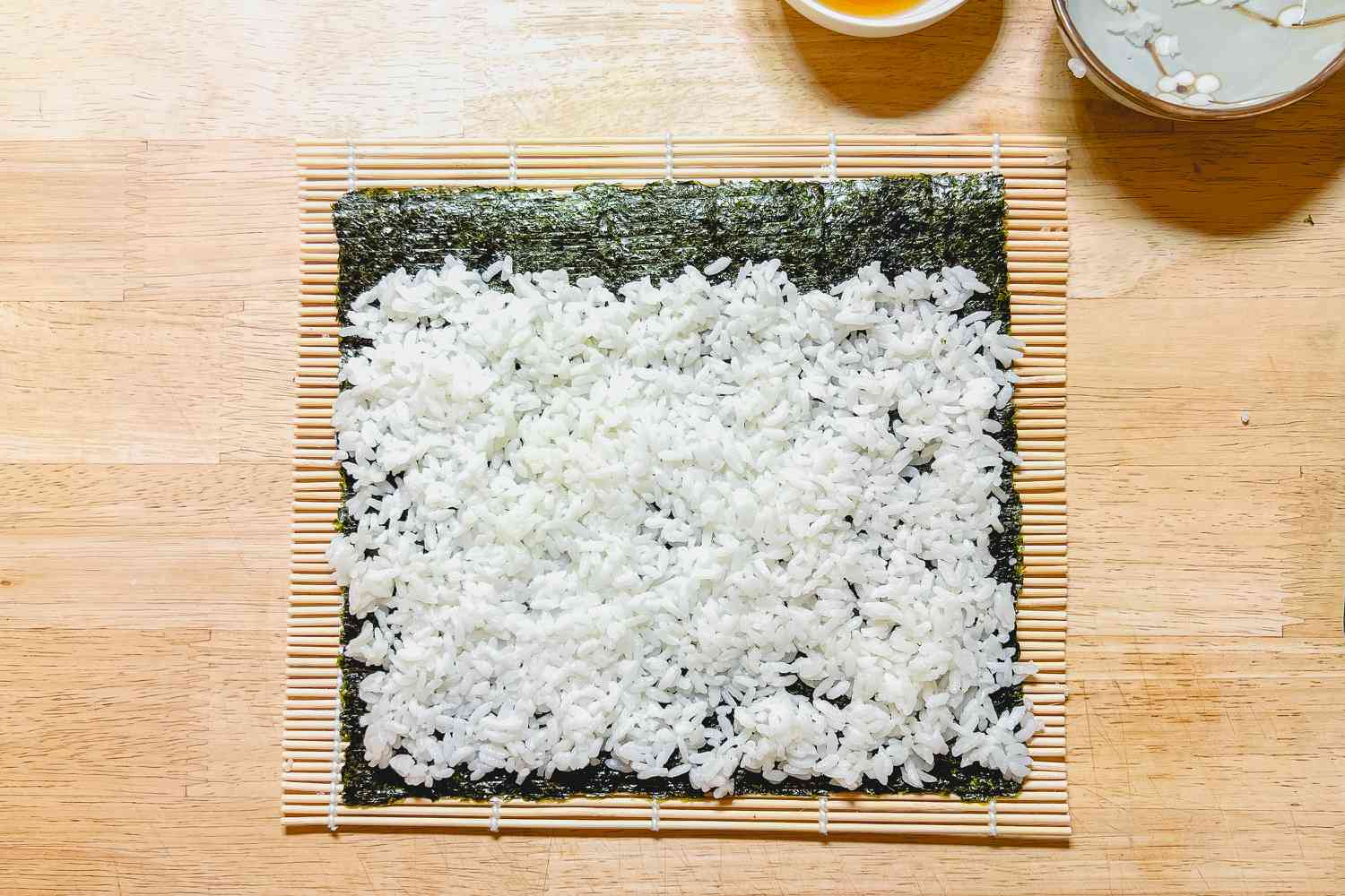 Rice on Sheet of Gim on Top of a Bamboo Sushi Rolling Mat for Kimbap