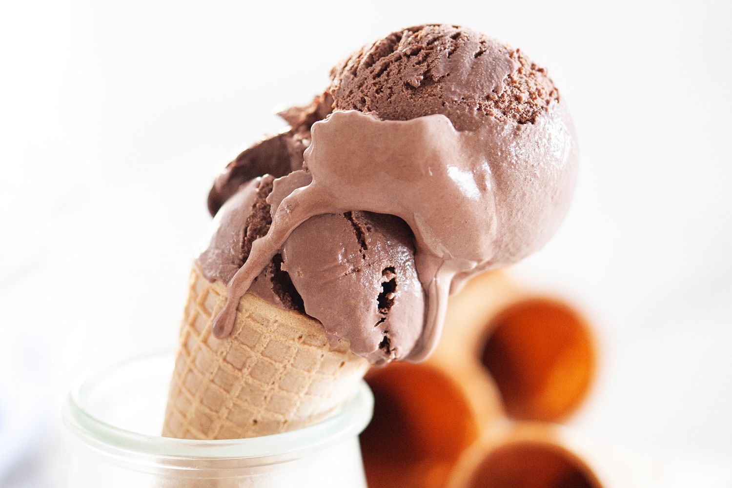 Double scoop of chocolate ice cream cone set in a dish.