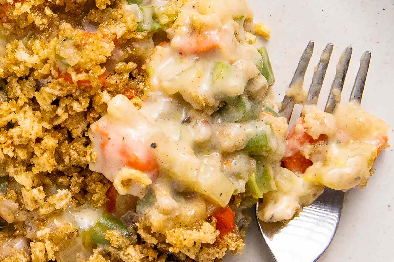 close-up view of Grandma's Creamy Vegetable Casserole with Crunchy Chex Topping on a plate with a fork