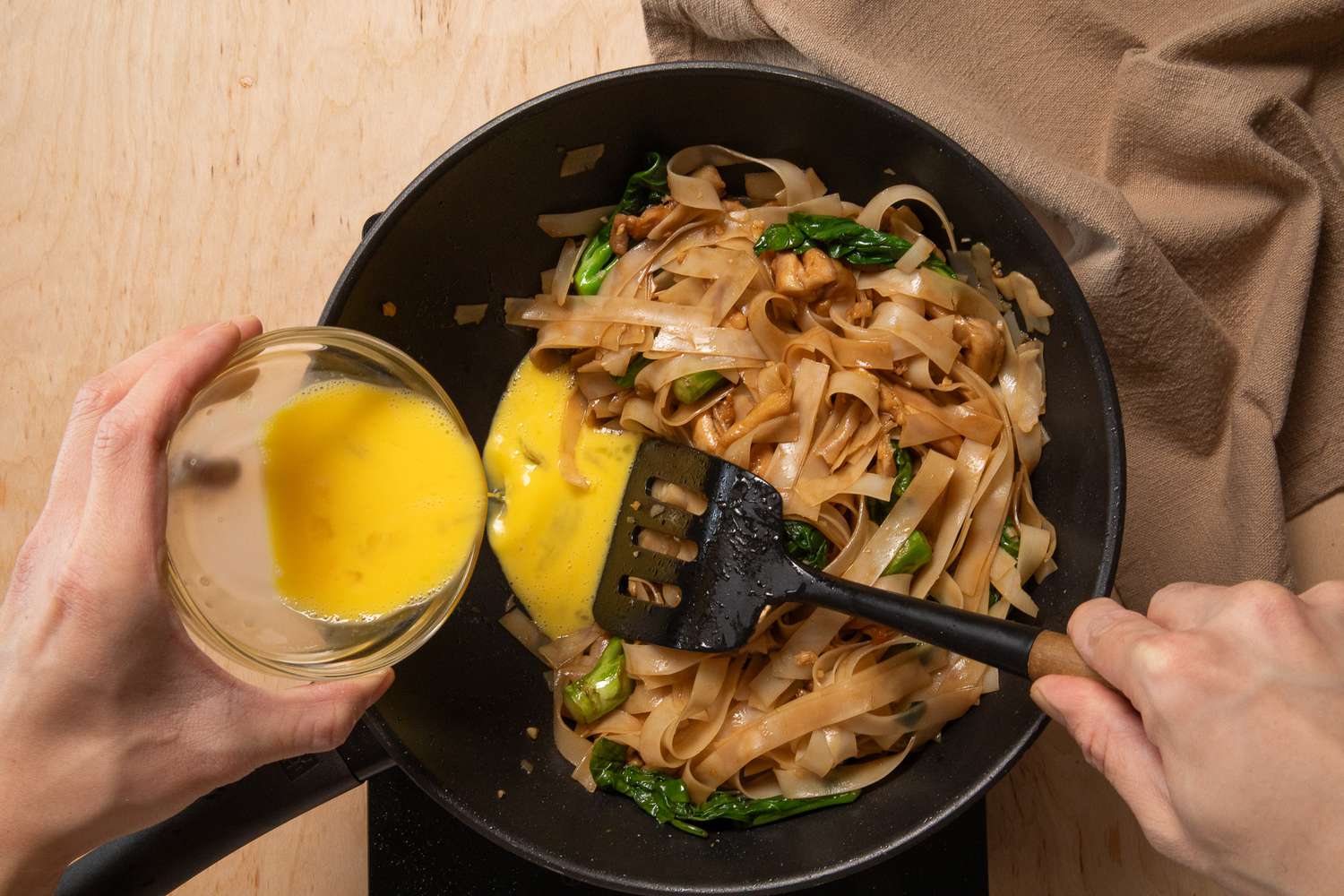 egg added to a corner of the wok for pad see ew recipe