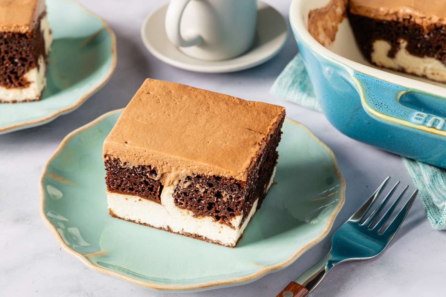 A slice of Italian love cake on a plate with a serving dish and a fork nearby