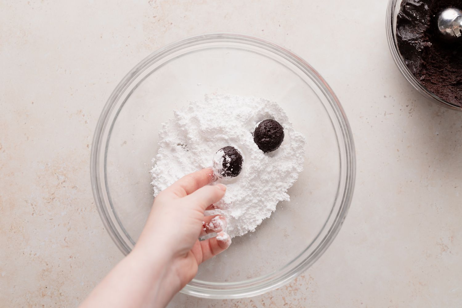 Rolling dough for chocolate crackle cookies in powdered sugar