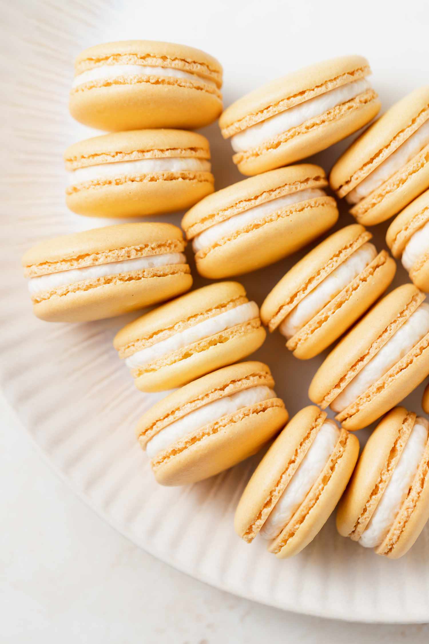 Overhead view of French macarons filled with lemon buttercream set on their side.