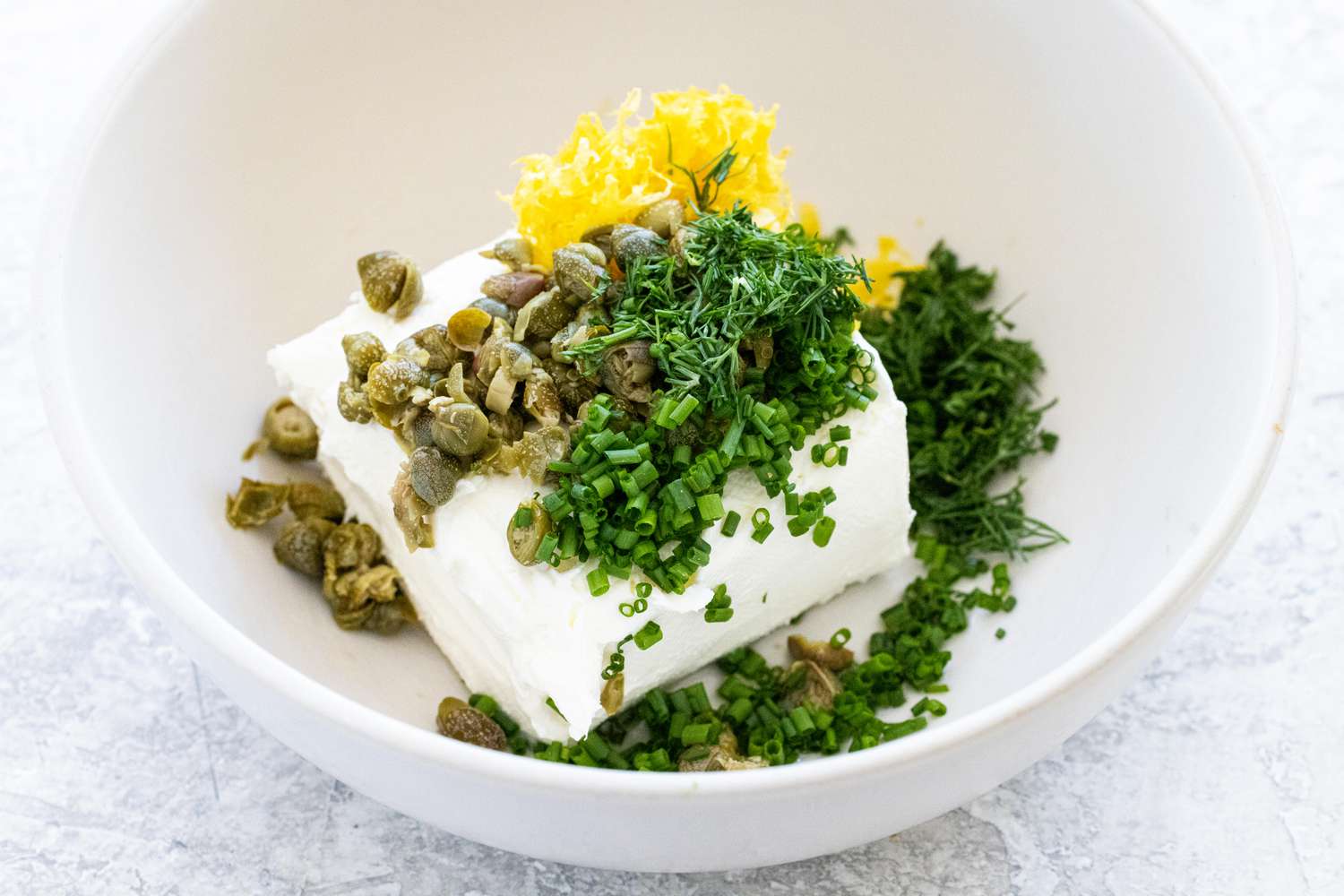Ingredients n a bowl to make the cream cheese spread for smoked salmon crostinis.