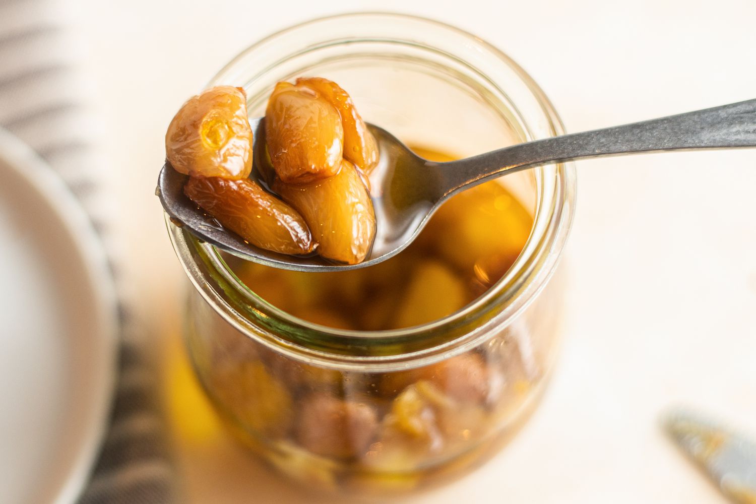 Garlic Confit Scooped up with a Spoon from a Jar