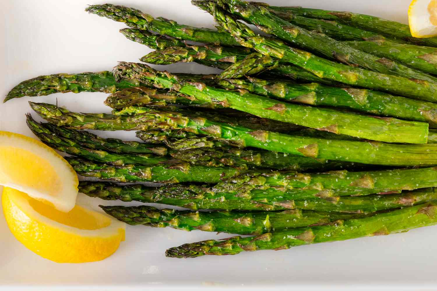air fryer asparagus on a platter with lemon slices