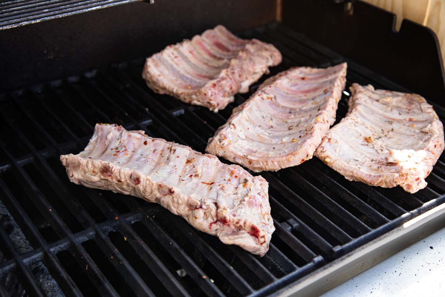 Four racks of bbq ribs grilling.