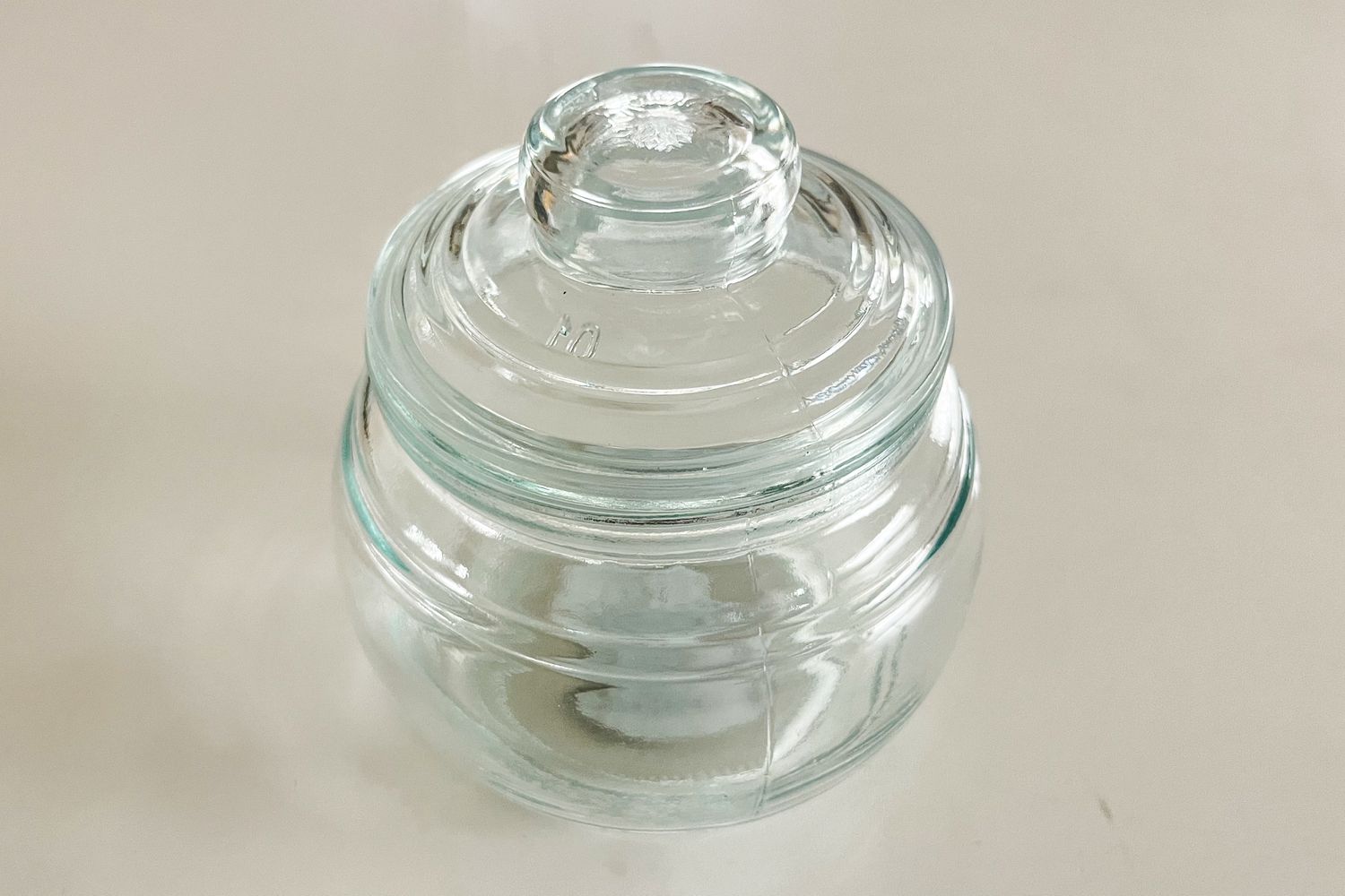 A clear glass apothecary jar with a lid