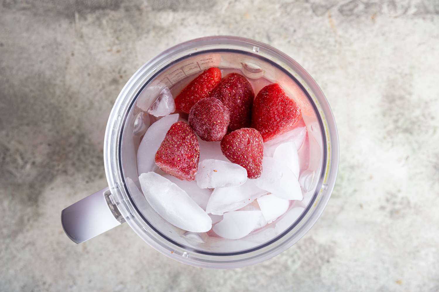 Ice, Strawberries and Other Ingredients in Blender for Frozen Strawberry Daiquiri Recipe