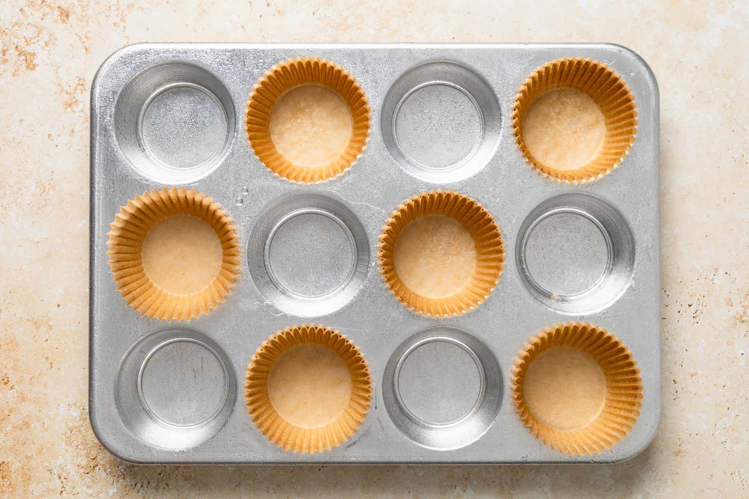 Muffin tray lined with muffin liners (every other cavity) for bran muffins recipe