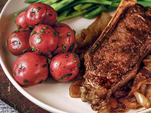 Steak with sweet onions served with red potatoes and green beans
