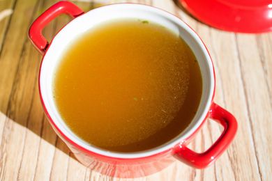 chicken broth in a red bowl