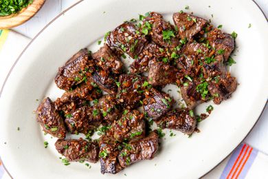 Overhead view of a white platter of Garlic Butter Steak Bites