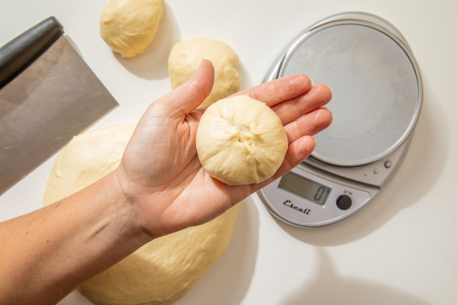 Shaping the rolls: edges of the roll pinched and brought to the center to form a ball for salted honey rolls recipe